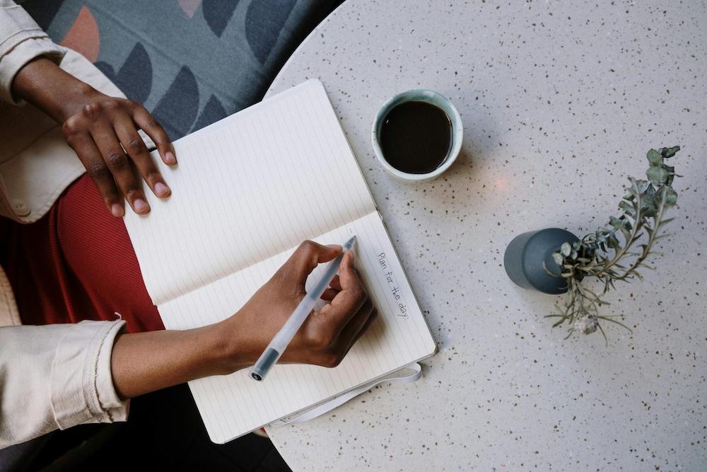 Planning your clothes is one idea for smart travel packing from Personal Image Consultant Beth Divine image shows person writing plan on paper