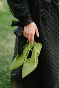 Find ways to enhance your wardrobe by speaking with Personal Image Consultant Beth Divine image shows pair of green shoes hanging on fingertips